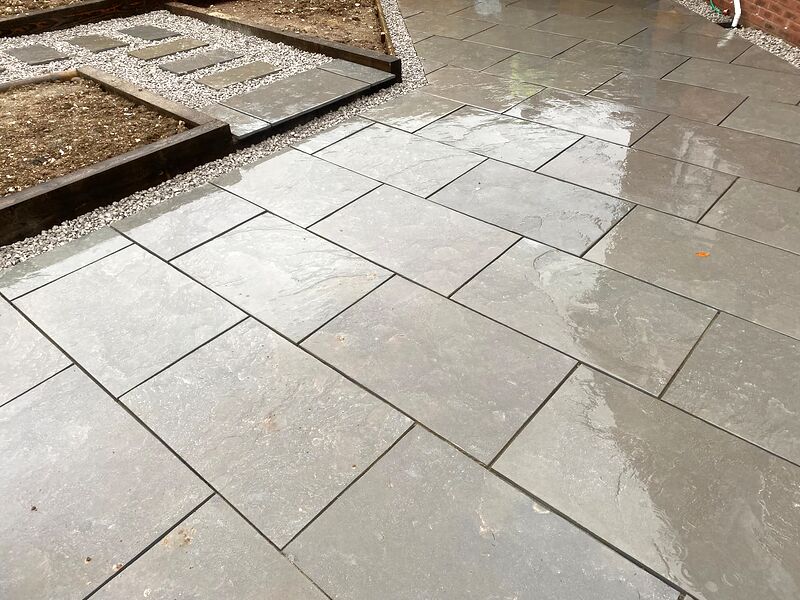 Close view of riven grey paving slabs with neat joints in a garden patio